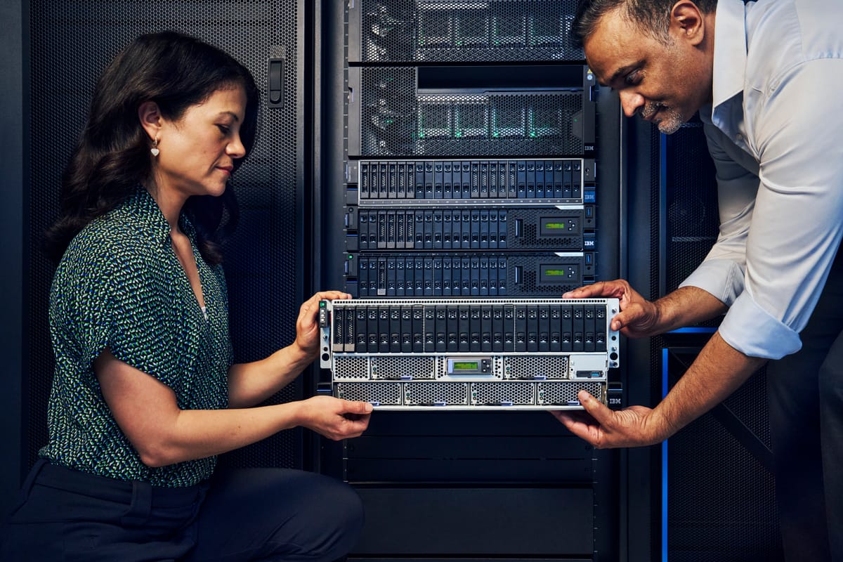 Two people install one of IBM's new Power11 servers in a rack.