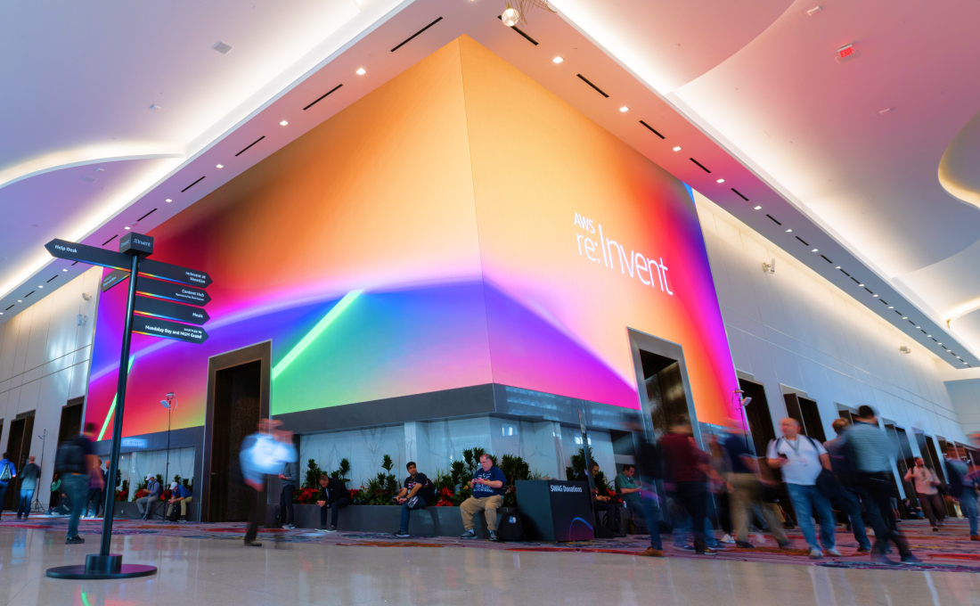 People attending AWS re:Invent in a convention center walk between sessions.
